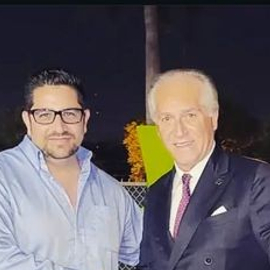 Marcos Bravo posing with older gentleman